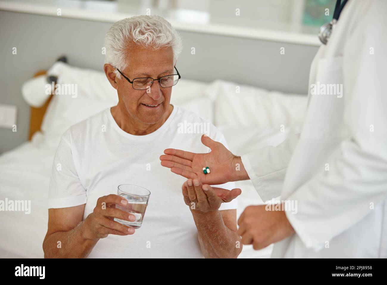 Vous vous sentirez mieux en un rien de temps. un médecin donnant à son patient âgé une dose de médicaments dans un établissement de vie assisté. Banque D'Images