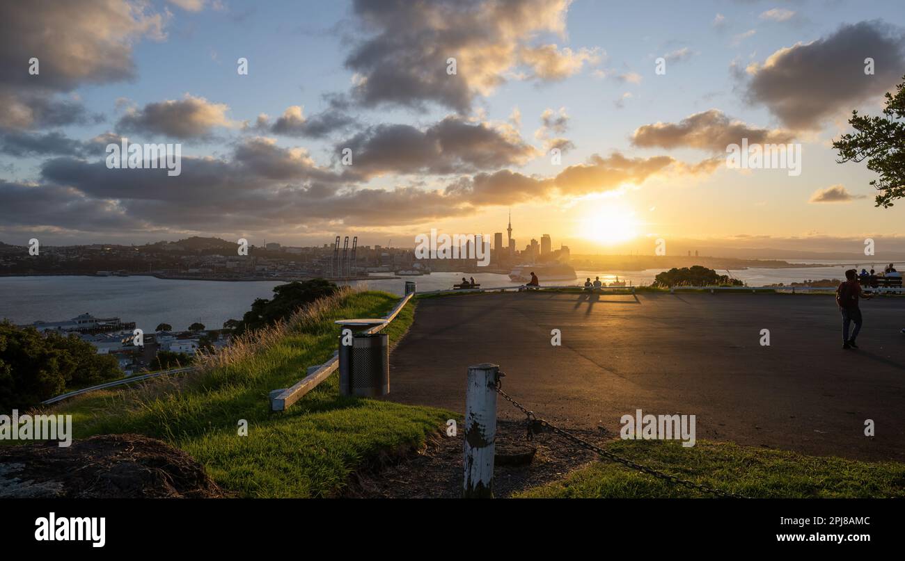 Coucher de soleil à Auckland avec bateau de croisière naviguant dans le port de Waitemata. Vue depuis le Mont Victoria, Devonport. Banque D'Images