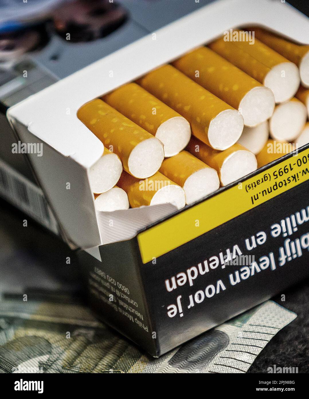 HAARLEM - Un paquet de cigarettes avec deux pices de 2 euros et une note de  5 euros. L'accise sur le tabac augmentera de 1,22 euros le samedi 1 avril.  Pour un