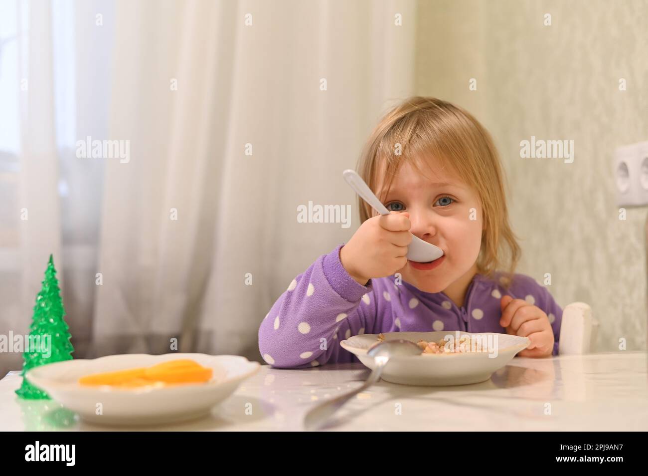 une petite fille mange Banque D'Images