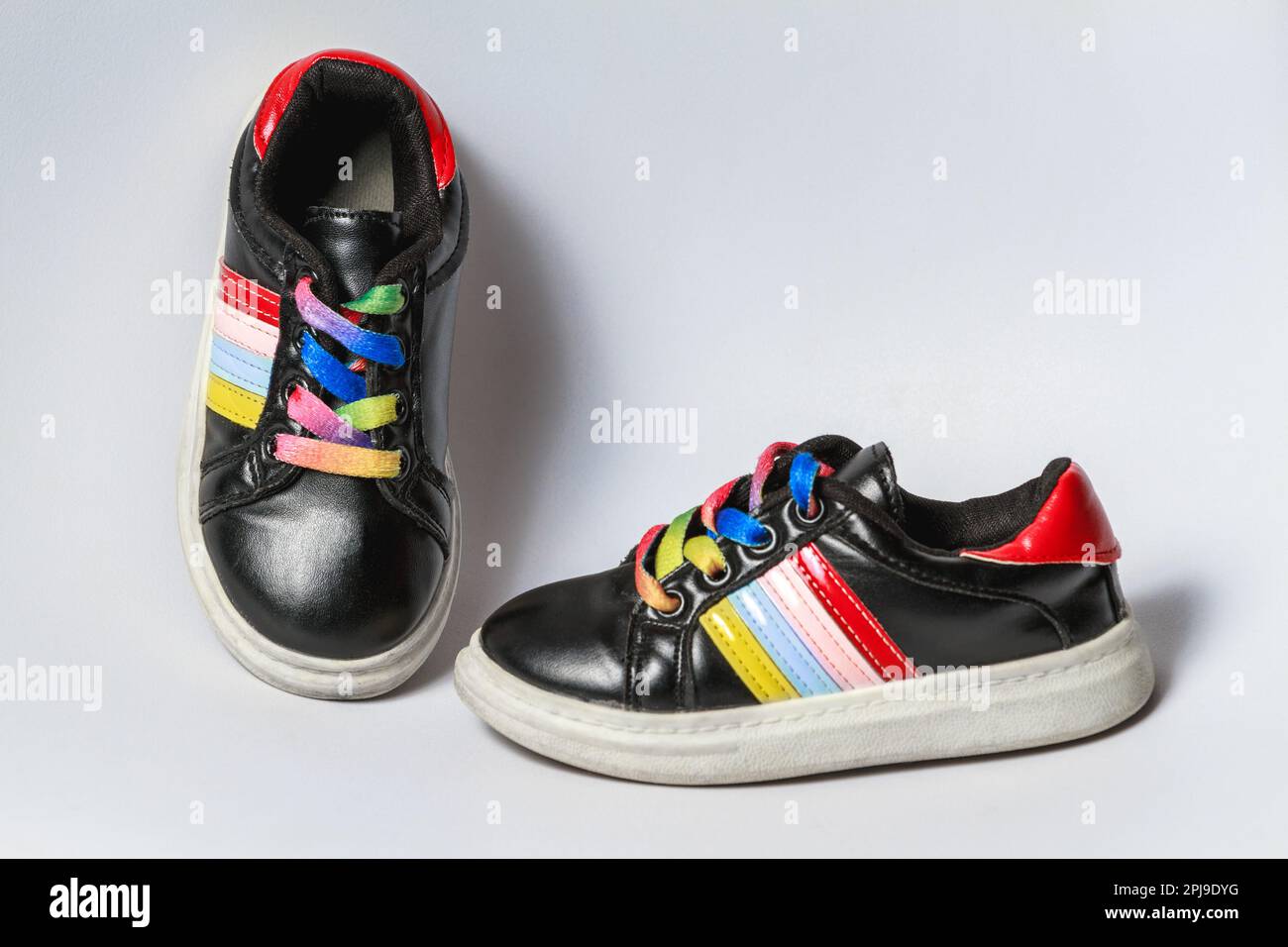 Jolies chaussures de sport noires pour enfants avec lacets colorés en arc-en-ciel Banque D'Images