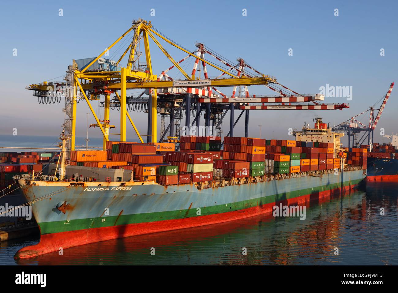 Livourne, Italie - 08 20 2023: Terminal à conteneurs avec conteneurs rangés de différents expéditeurs grues portiques et chariots à cheval à Livourne. À hori Banque D'Images