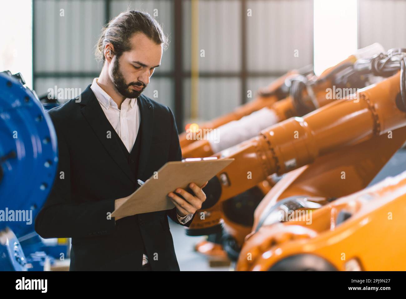 Homme d'affaires travaillant dans l'usine d'assemblage de machines de l'industrie lourde pour commercial de produits industriels. Banque D'Images