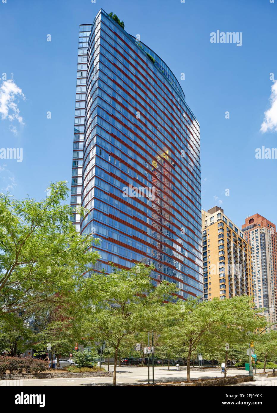 Visionaire est un immeuble d'habitation en copropriété situé dans Battery Park City avec une façade en verre incurvée distinctive accentuée par des bandes horizontales rouges. Banque D'Images
