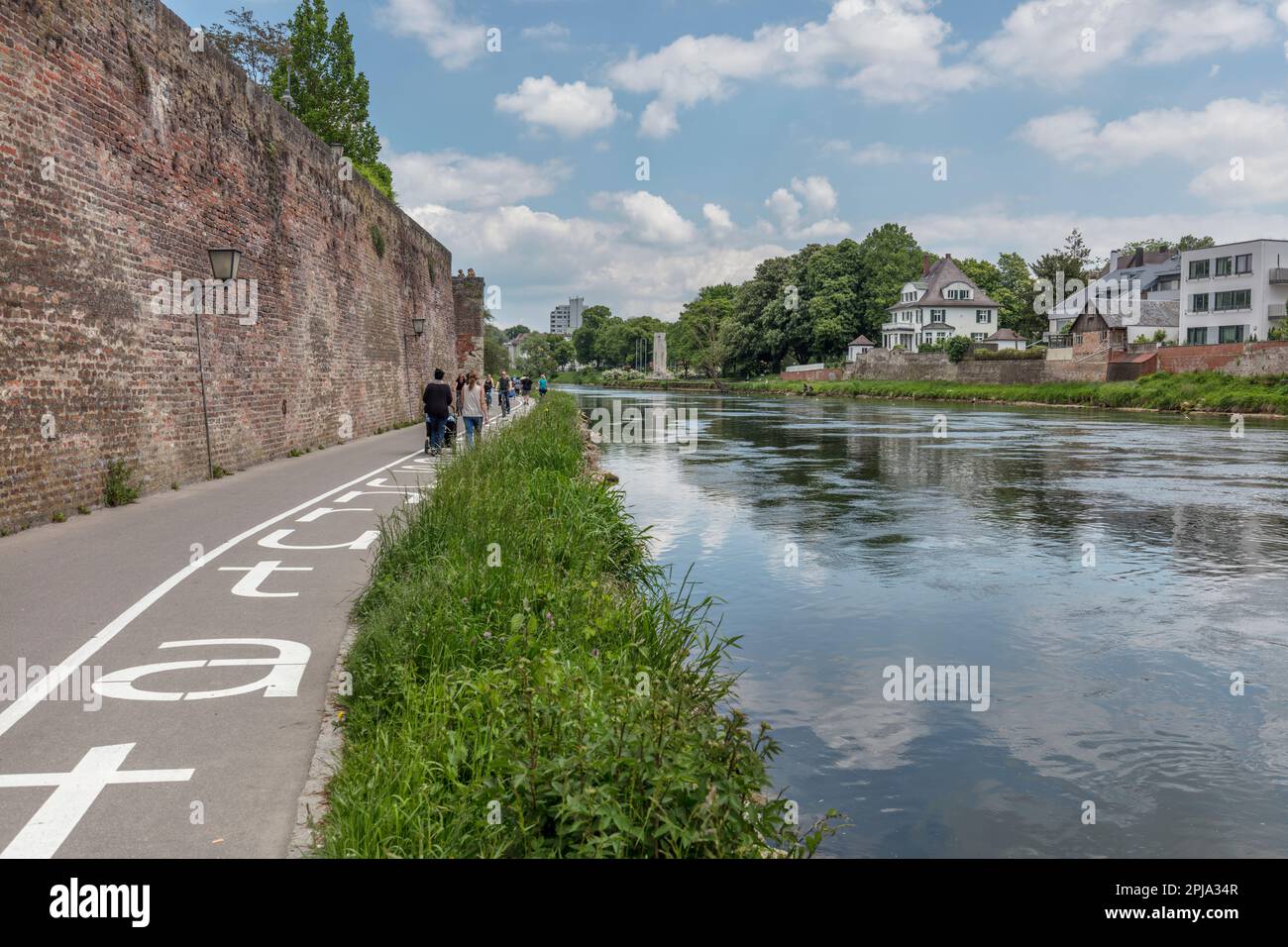 Les gens marchent par Herdbruckerstrasse mur défensif partie des remparts de la ville par le Danube bord de la rivière avec Neu Ulm (à droite). Ulm. Banque D'Images