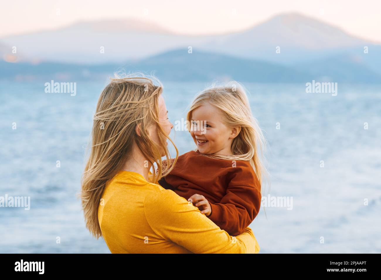 Mère et enfant fille marchant dehors famille voyage style de vie vacances mignon bébé avec maman heureux émotions paysage de lac Banque D'Images
