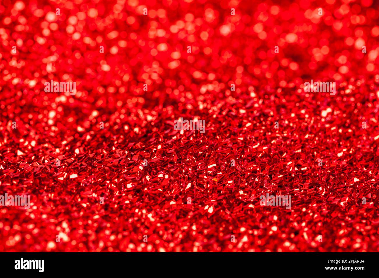 Tissu brillant rouge texture pailletée gros plan. Banque D'Images