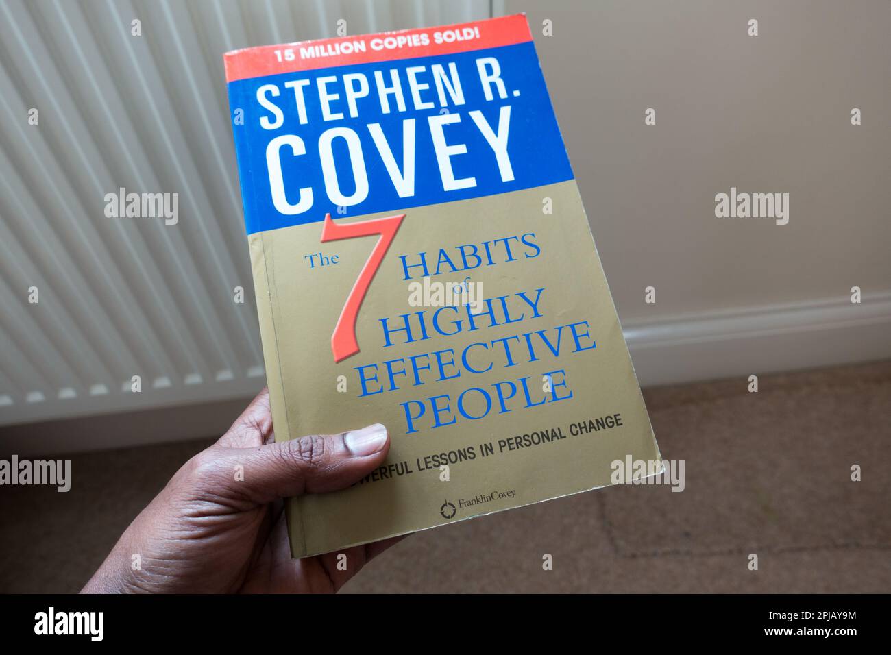 Photo d'un homme adulte tenant 7 habitudes de personnes très efficaces livre par Stephen R Covey Banque D'Images