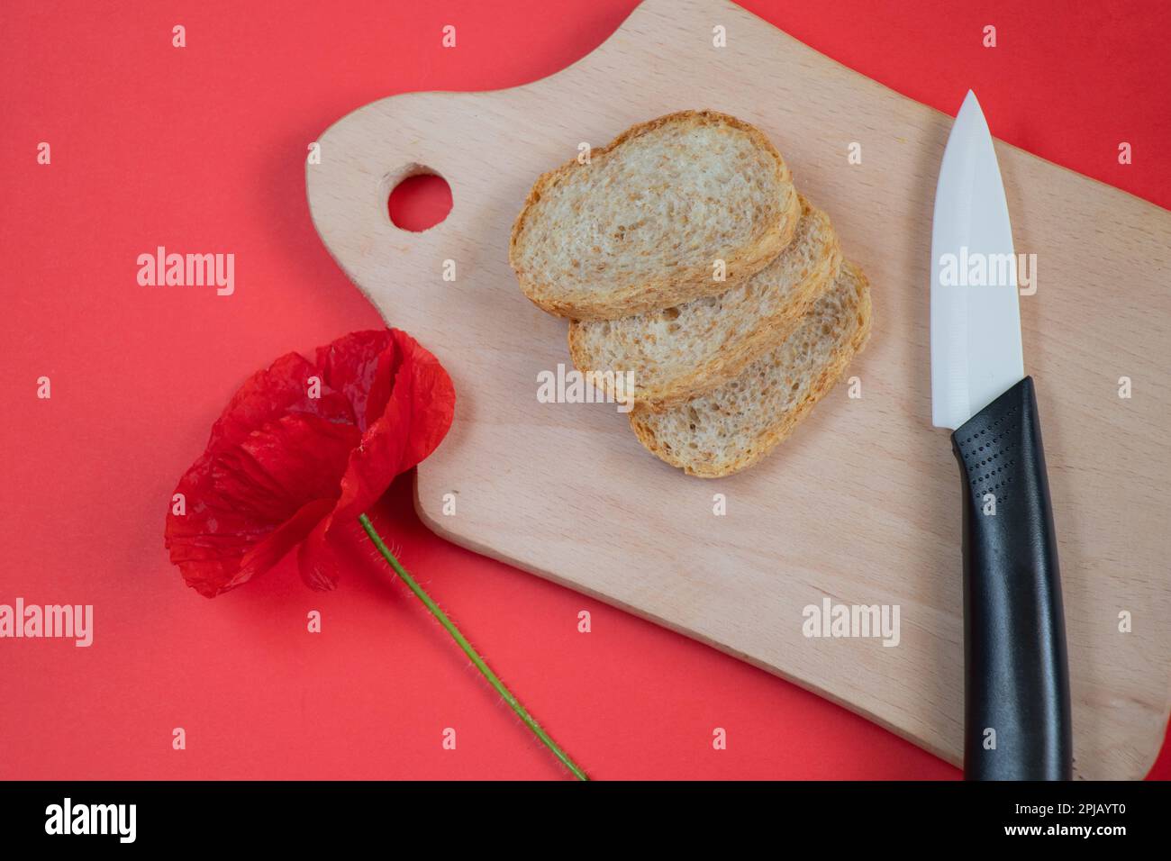 couteau en céramique et pain coupé en tranches sur un rouge dans la cuisine Banque D'Images