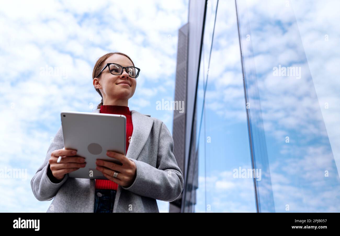 Femme d'affaires avec une tablette numérique à côté du bureau. Banque D'Images