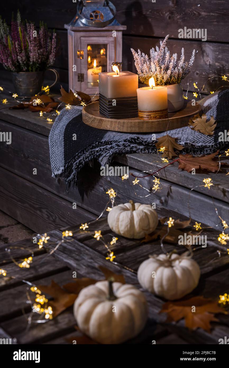 Terrasse d'automne ou patio de nuit avec citrouilles, lumières et plantes de bruyère (Calluna vulgaris) Banque D'Images