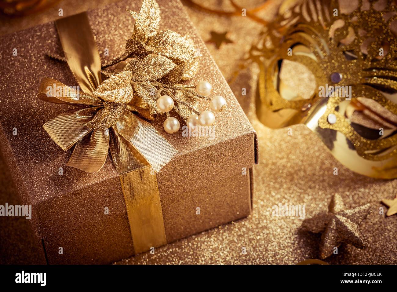 Boîte cadeau dans un ton doré avec masques de carnaval vénitiens dorés sur  fond doré. Nouvel an, vacances ou fête d'anniversaire Photo Stock - Alamy