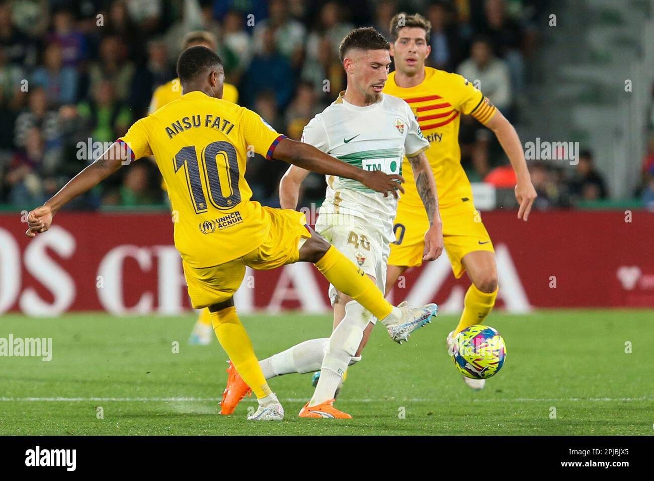 Barcelona's Ansu Fati, left, duels for the ball with Elche's Jose Ángel Carmona during a Spanish La Liga soccer match between Elche and Barcelona, at the Martinez Valero Stadium in Elche, Spain, Saturday, April 1, 2023. (AP Photo/Alberto Saiz) Banque D'Images