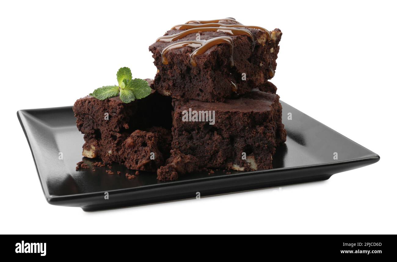 Délicieux brownies au chocolat avec noix, sauce caramel et menthe fraîche sur fond blanc Banque D'Images