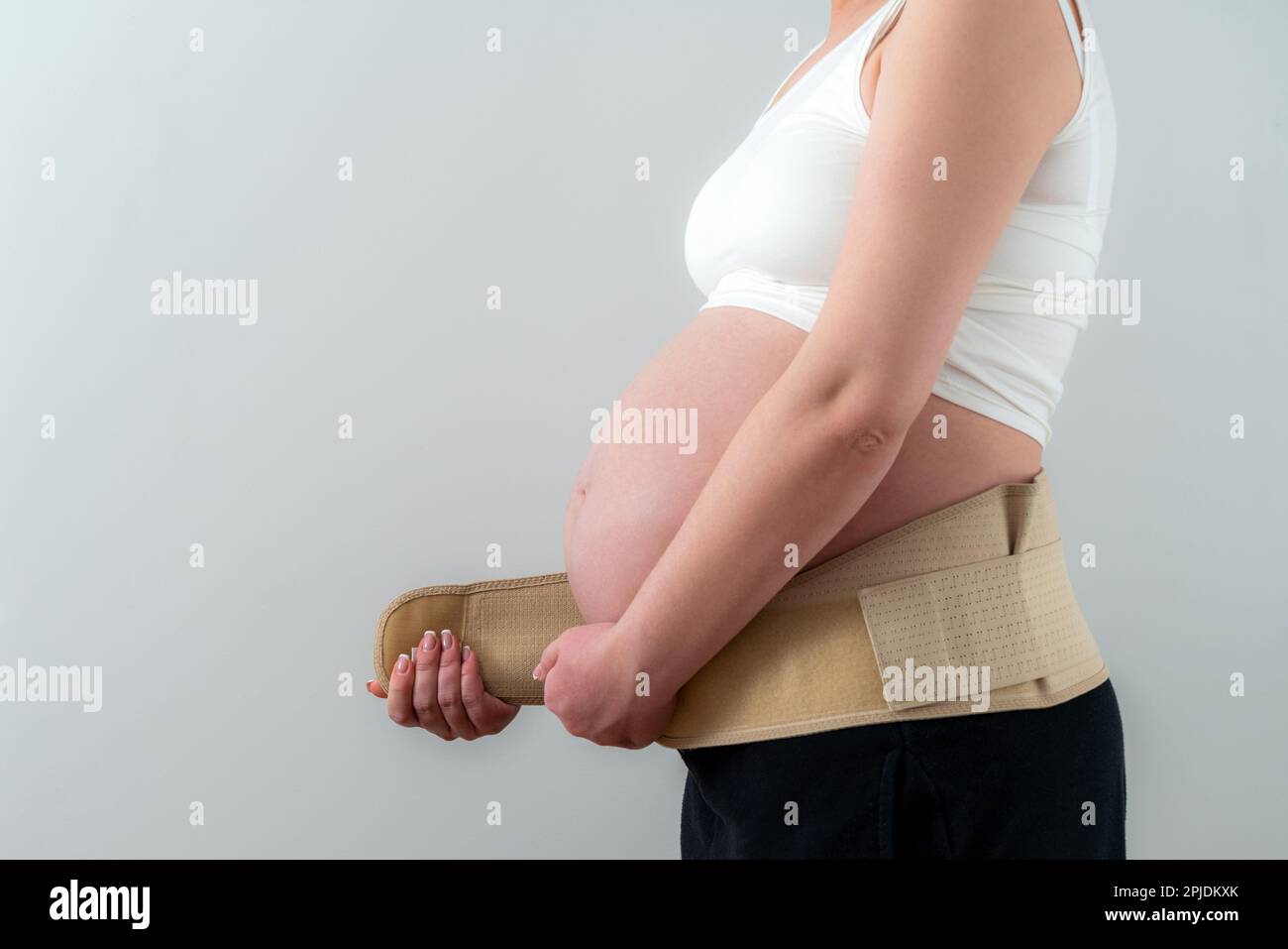 Femme enceinte mettant sur le bandage de soutien pour réduire le mal de dos.  Concept de ceinture abdominale orthopédique Photo Stock - Alamy