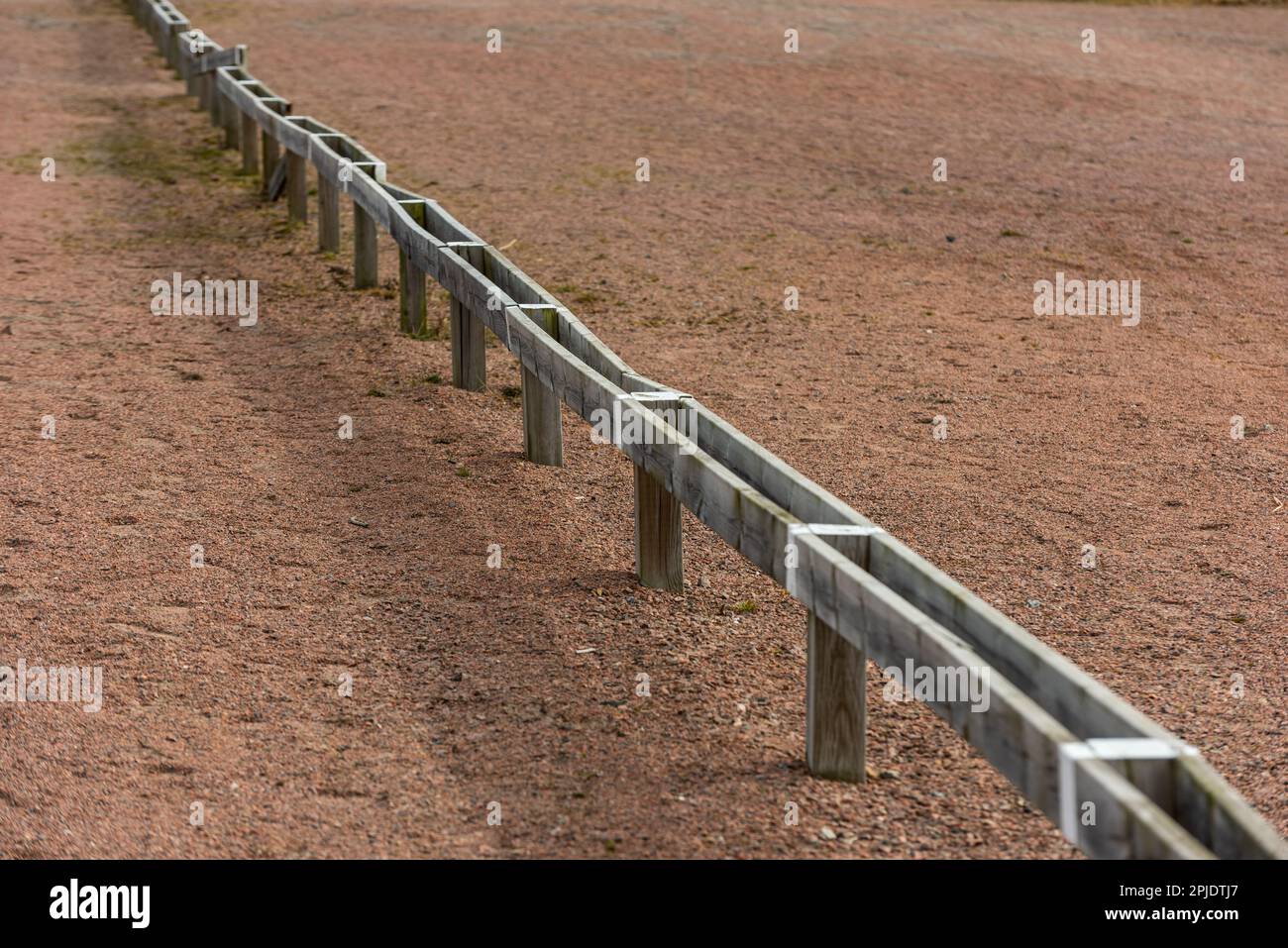 Barrières en bois basses séparant les places de stationnement sur un parking. Banque D'Images