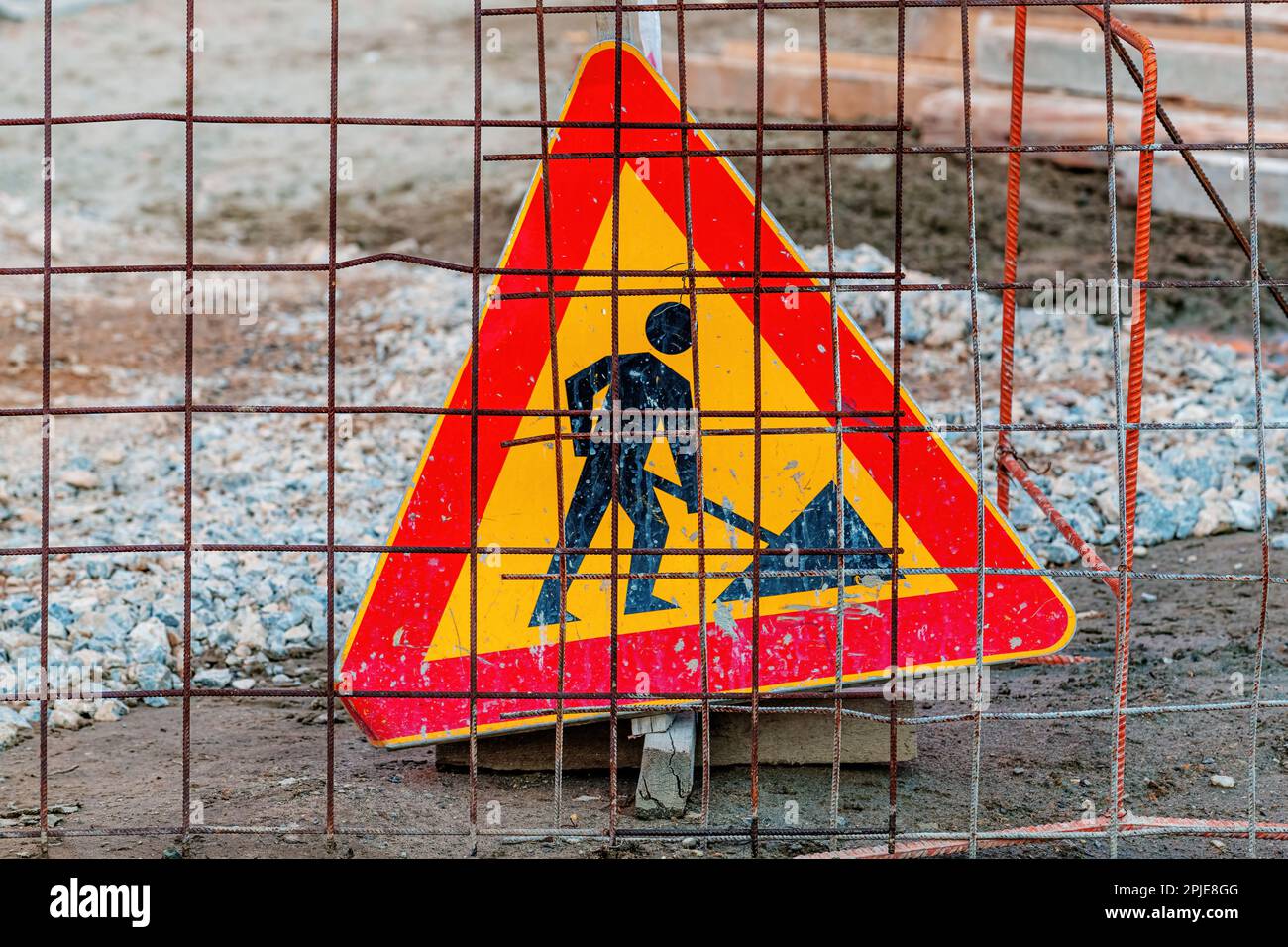 Panneau hommes au travail derrière la clôture en fil d'acier sur le chantier, attention sélective Banque D'Images
