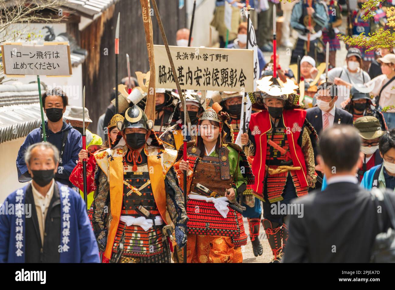 Défilé de personnes habillées en costume de samouraï marchant vers le spectateur. Vue en perspective compressée du front de la parade de marche qui fait partie du festival printanier à Hon-Tatsuno au Japon. Banque D'Images