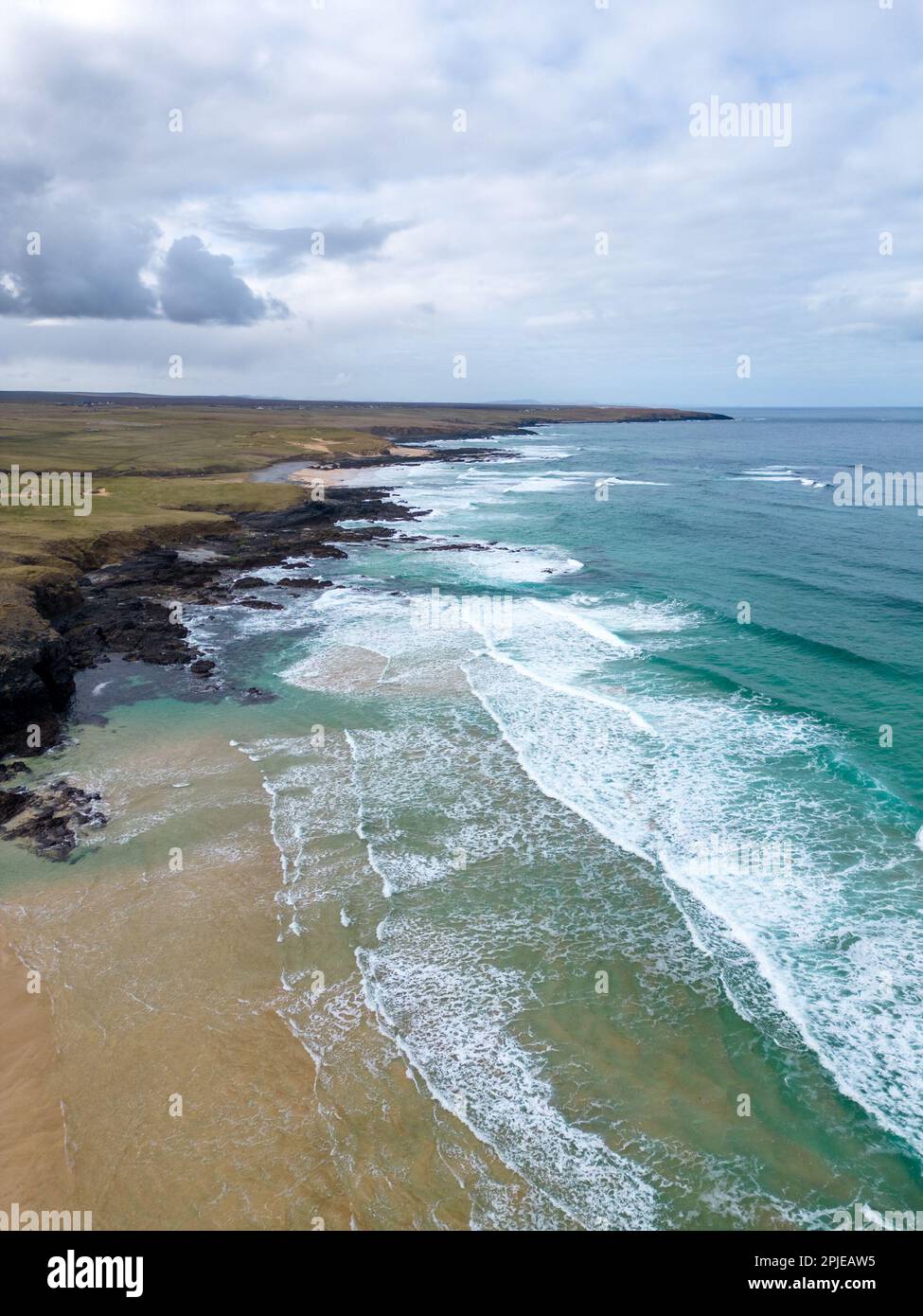 Vue ériale des vagues brisées et de la mer turquoise formant des motifs naturels le long d'une plage de sable isolée sur l'île de Lewis, en Écosse. Banque D'Images