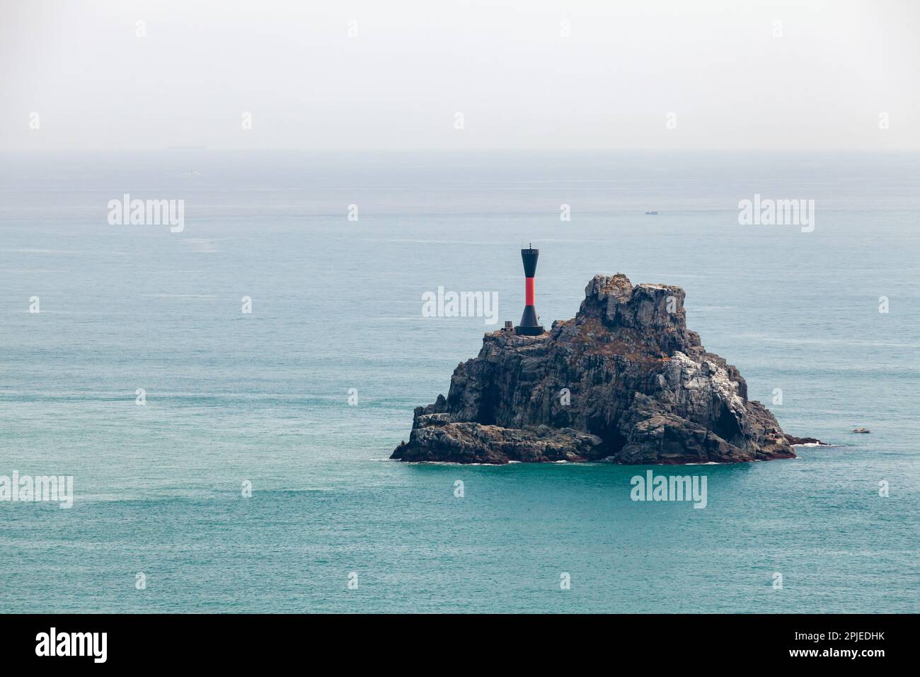 Repère de danger isolé. Tour de balise noire avec une bande rouge est sur un petit îlot rocheux dans la mer du Japon près de la ville de Busan, Corée du Sud Banque D'Images