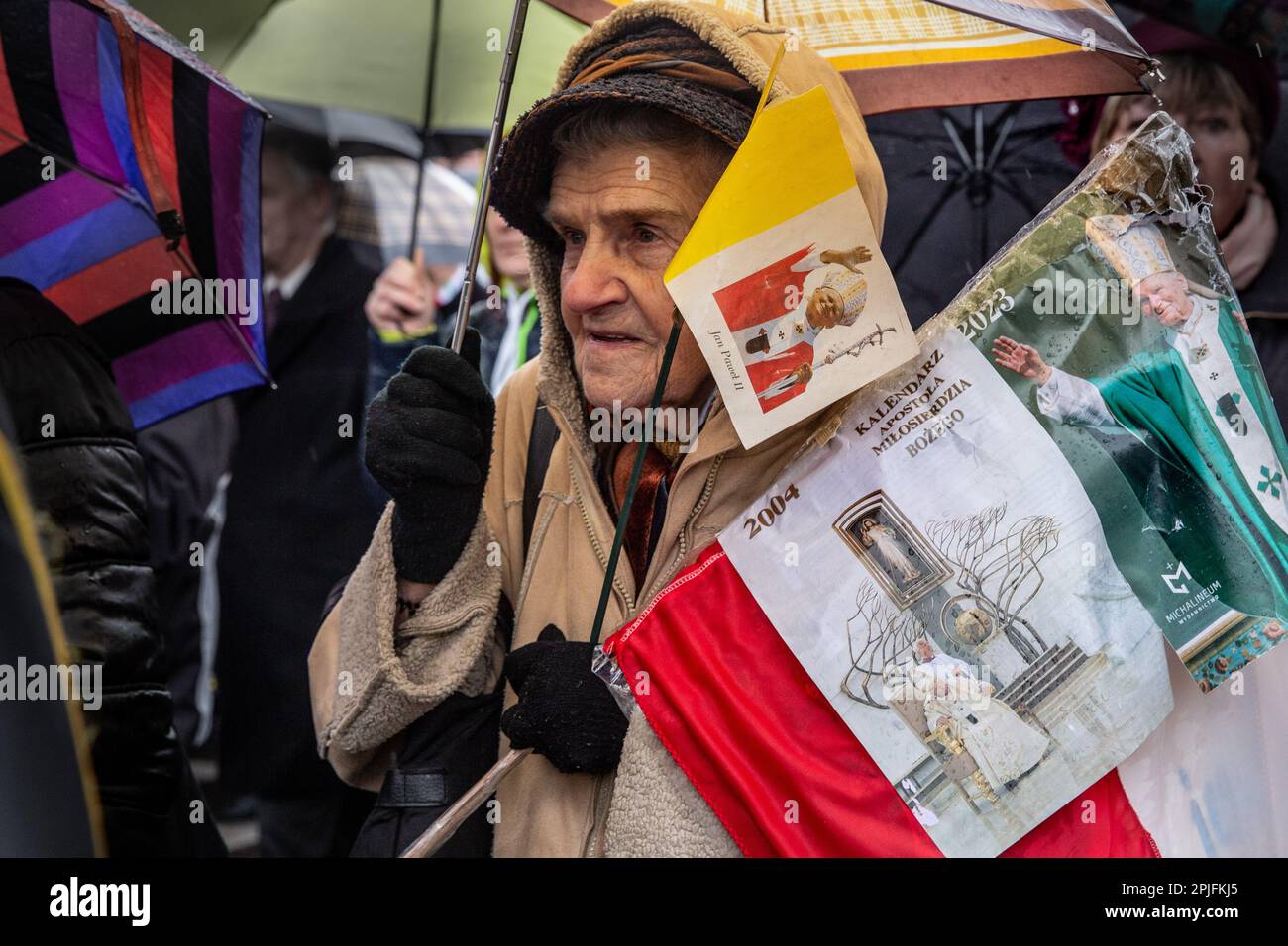 Une femme porte des drapeaux papal alors que des milliers de personnes  participent à une marche papale blanche dans le centre de Cracovie, en  Pologne, à l'anniversaire de la mort de Jean-Paul