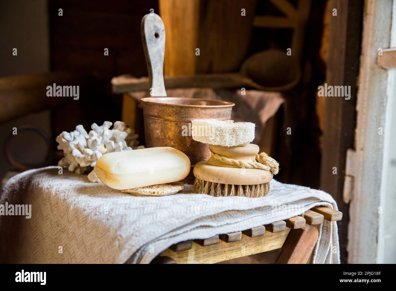 Sauna finlandais traditionnel en bois dans les détails. Ensemble d'accessoires de bain - éponge biologique loofah, brosse naturelle et savon fait à la main. Intérieur rustique ancien. Banque D'Images