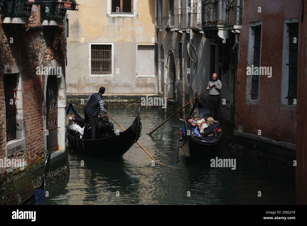 Les gondoliers bordent leurs gondoles avec des touristes à bord le long des canaux de Venise, Italie, 2 avril 2023 Banque D'Images
