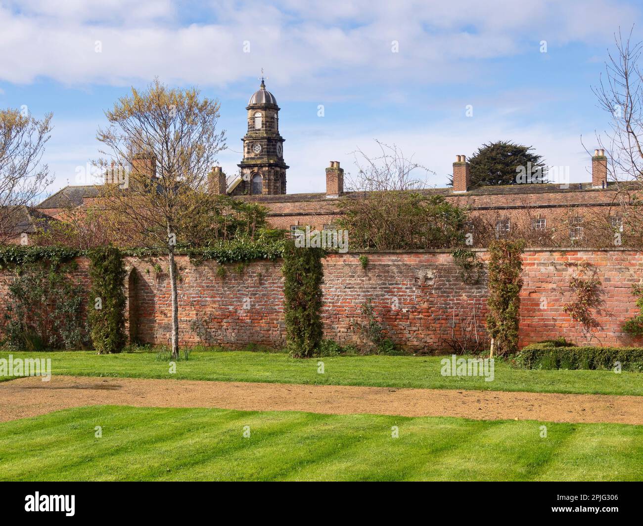 Les cheminées des maisons de l'Alms et la tour de l'horloge sur leur chapelle vue de l'intérieur du jardin fortifié de Kirkleatham Banque D'Images