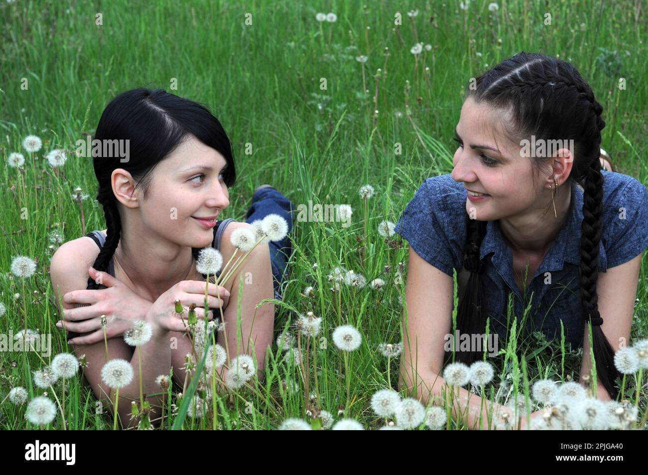 deux jeunes belles femmes dans la communication silencieuse à la prairie de printemps Banque D'Images
