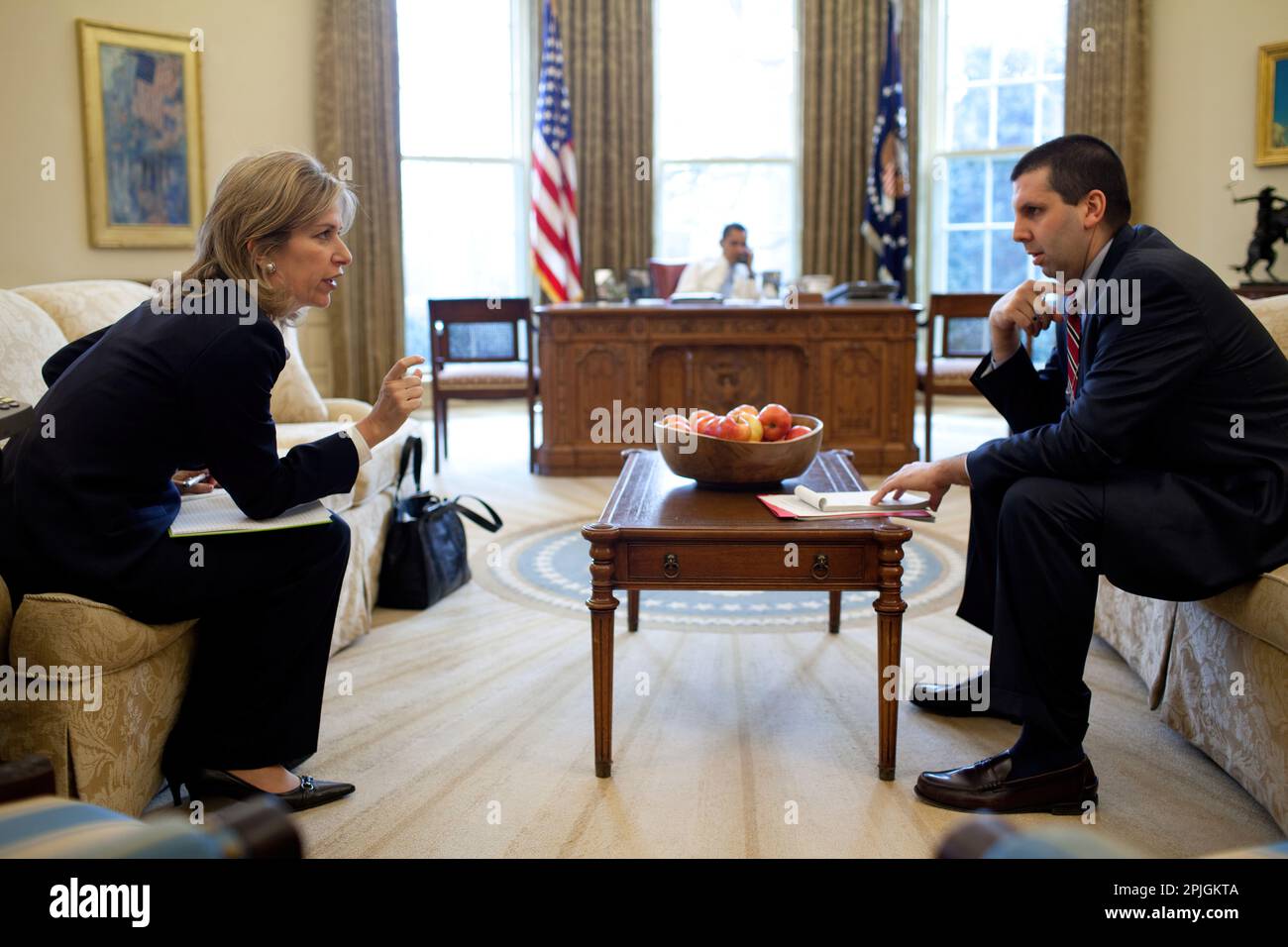 Le Dr Elizabeth 'Liz' Sherwood-Randall, directeur principal du Conseil de sécurité nationale pour les affaires européennes et NSC Chef de cabinet Mark Lippert conférer dans le bureau ovale tandis que le président Barack Obama parle au téléphone avec un dirigeant étranger 2/16/09. Photo Officiel de la Maison Blanche par Pete Souza Banque D'Images