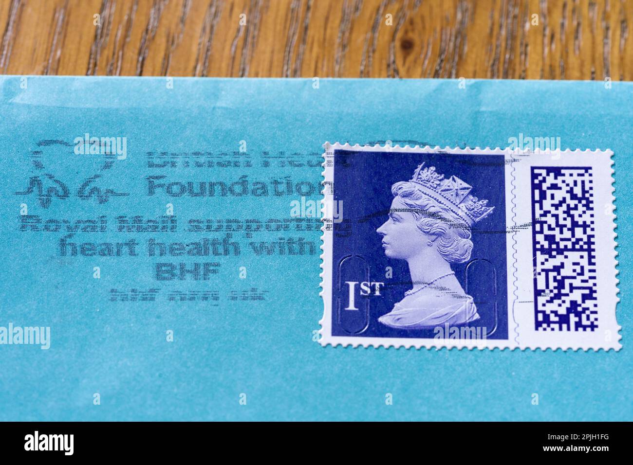 Timbre Elizabeth II de première classe de Royal Mail avec code QR, sur une enveloppe et sur une enveloppe affranchie montrant Royal Mail soutient des organismes de bienfaisance et des causes caritatives Banque D'Images