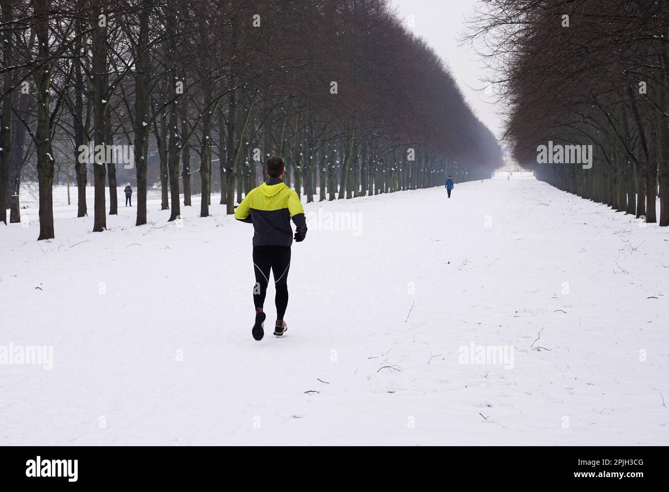 Groupe de personnes exécutant le jogging et la marche dans la neige en hiver Banque D'Images