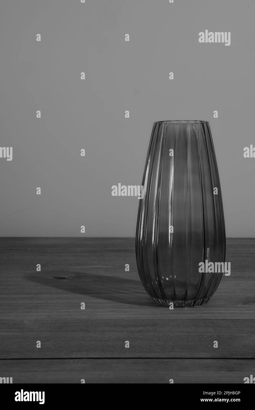 image monochrome noir et blanc d'un vase en verre sur une table en bois vide Banque D'Images