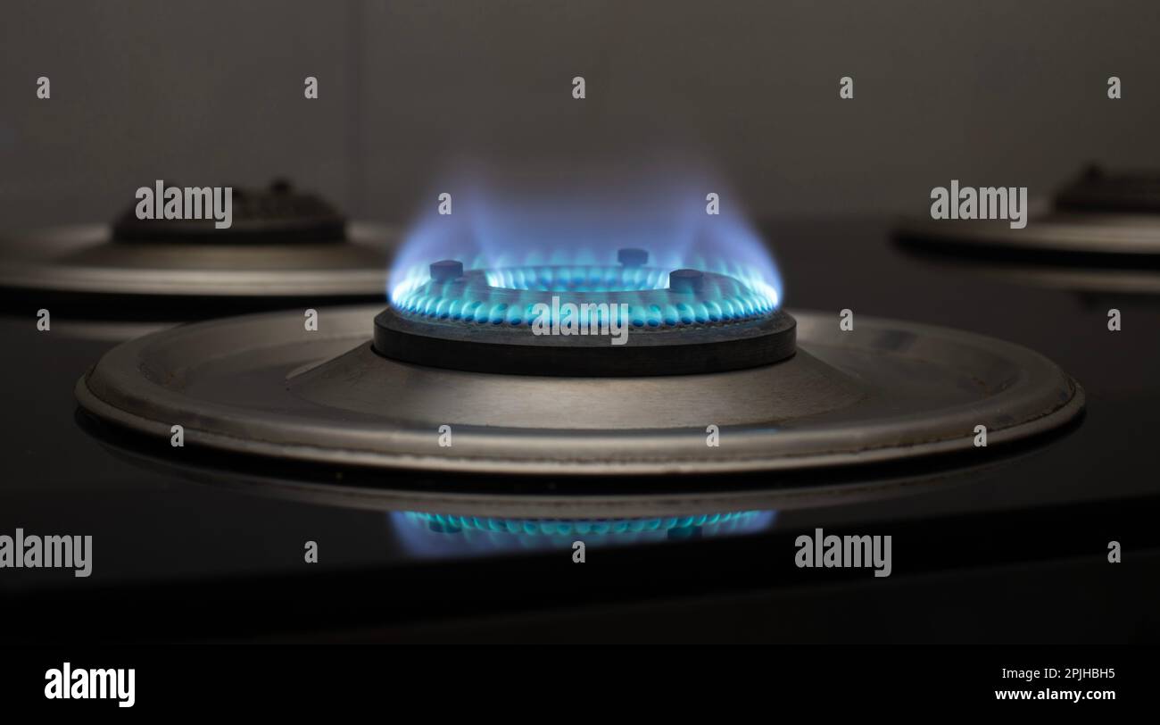 Vue de près latérale d'un brûleur domestique avec flamme bleue Banque D'Images