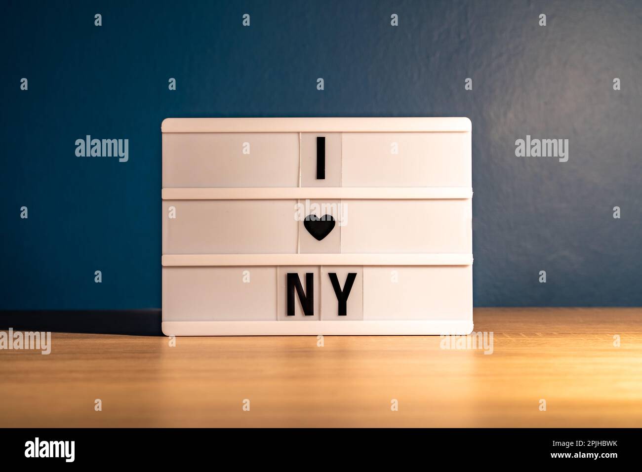 J'aime New York. Tableau blanc sur une table en bois avec phrase « I love New York ». Concept Voyage aux États-Unis Banque D'Images