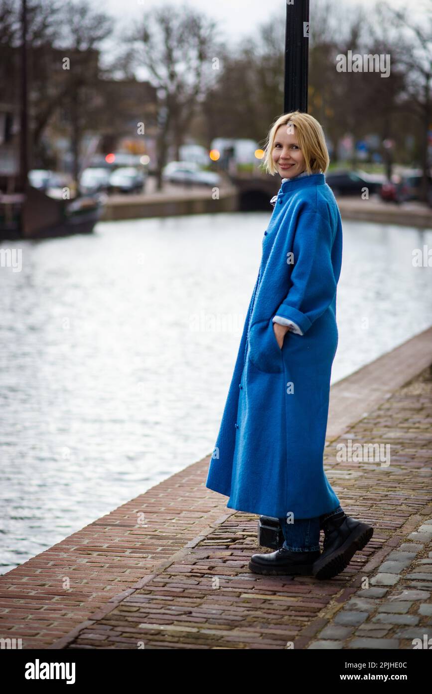 Une femme au long manteau bleu aux pays-Bas. Touriste lors de votre voyage  à Rotterdam. Une femme adulte près du canal Photo Stock - Alamy