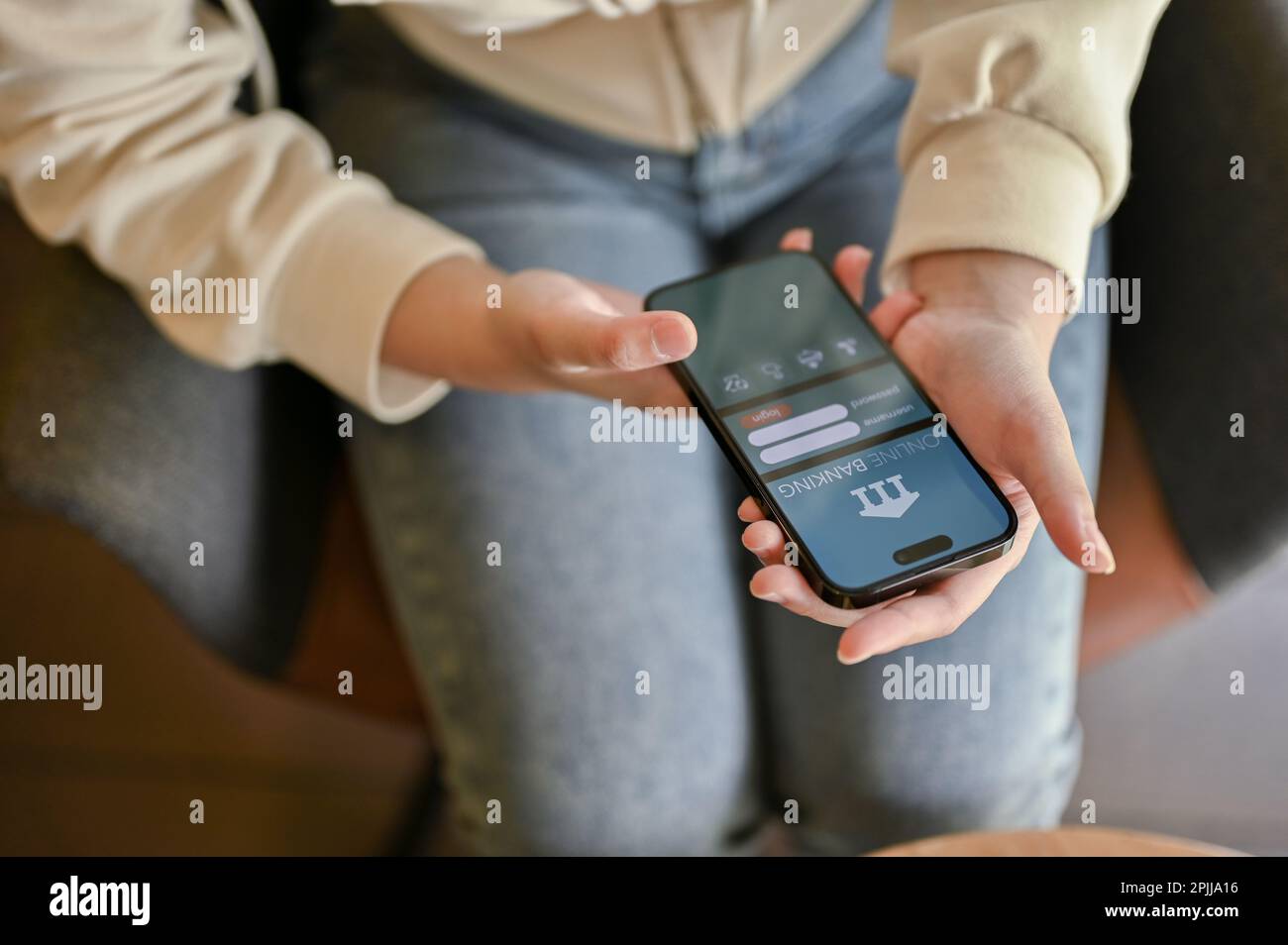 Chiang Mai, Thaïlande - 31 mars 2023: Une femme dans des vêtements décontractés en utilisant une application de banque mobile en ligne. IPhone avec logo de banque en ligne sur scree Banque D'Images