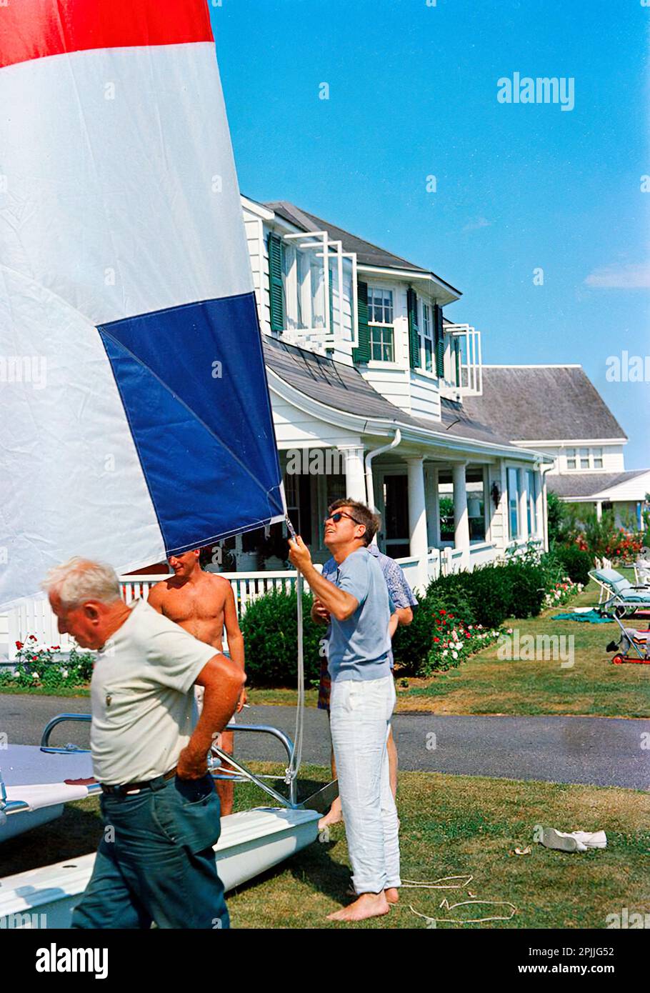 ST-C236-5-63 05 juillet 1963 week-end du jour de l'indépendance au port de Hyannis : lancement du voilier jouet de Caroline (cadeau du président italien Segni) avec Edward M. Kennedy (EMK) et K. LeMoyne ('Lem') Billings [les rayures sont originales au négatif.] Veuillez indiquer « Cecil Stoughton ». Photos de la Maison Blanche. John F. Kennedy Presidential Library and Museum, Boston Banque D'Images