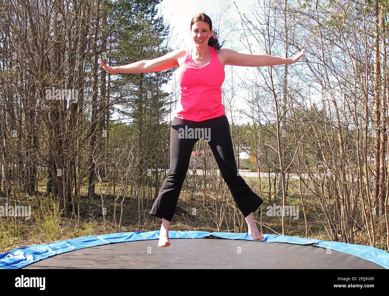 Umea, Norrland Suède - 13 mai 2017 : une femme saute sur le trampoline en plein air Banque D'Images