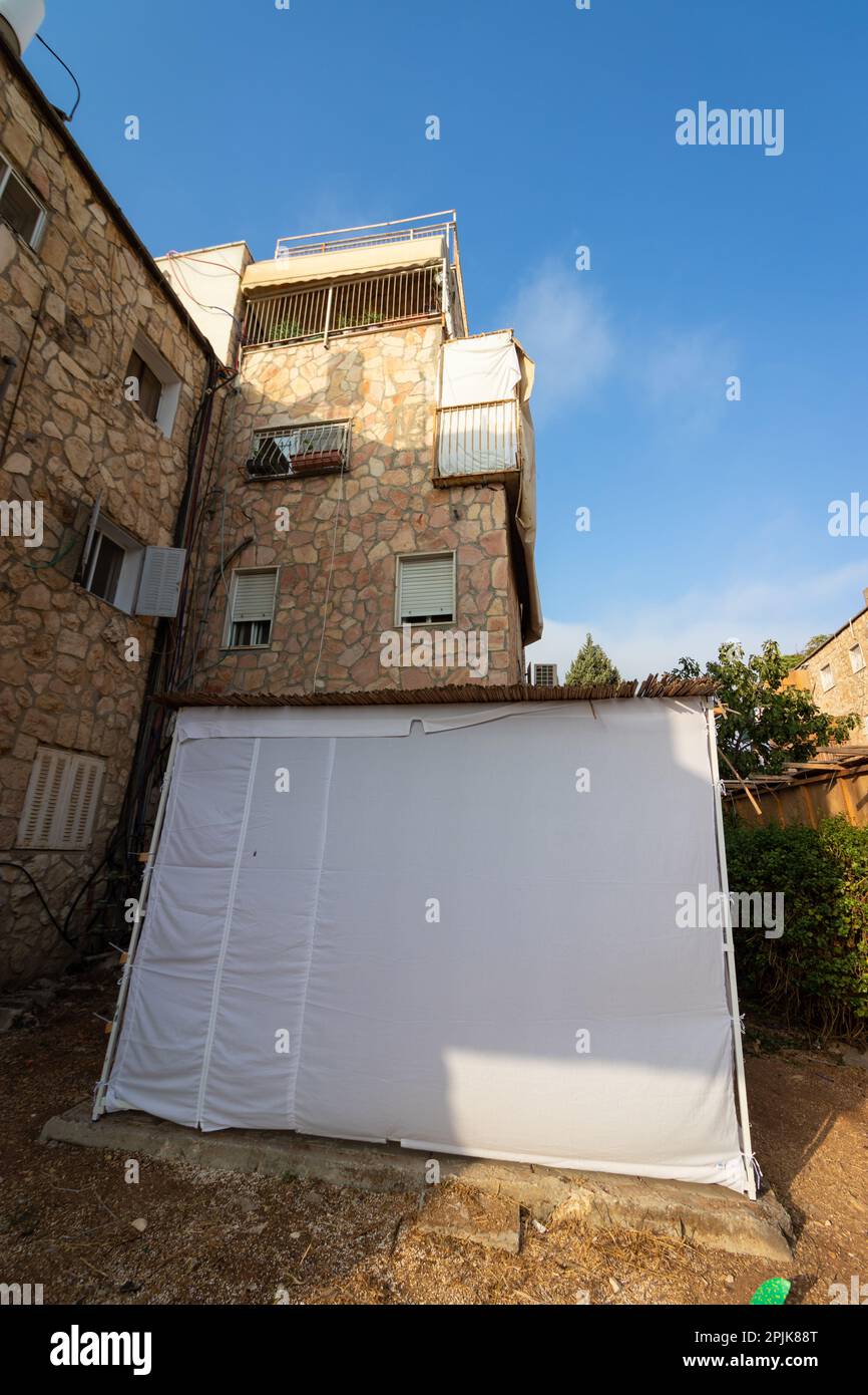 Sukkah recouvert de tissu blanc, construit dans la cour d'un bâtiment à Jérusalem. La fête juive de Sukkot Banque D'Images