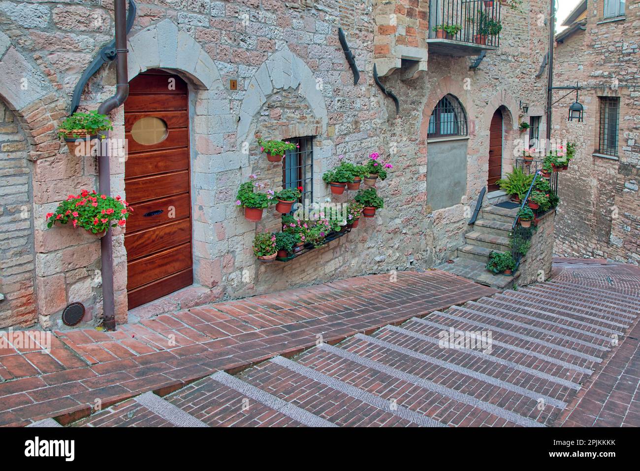 Italie, Ombrie, Assise. Promenade le long des rues d'Assise bordée de pots à fleurs. Banque D'Images