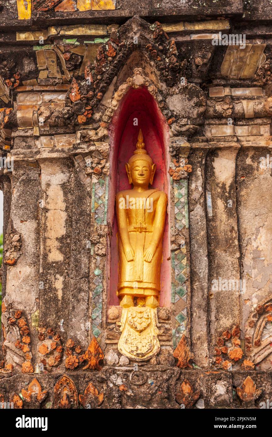 Laos, Luang Prabang. Statue de Bouddha dans une niche dans un mur. Banque D'Images