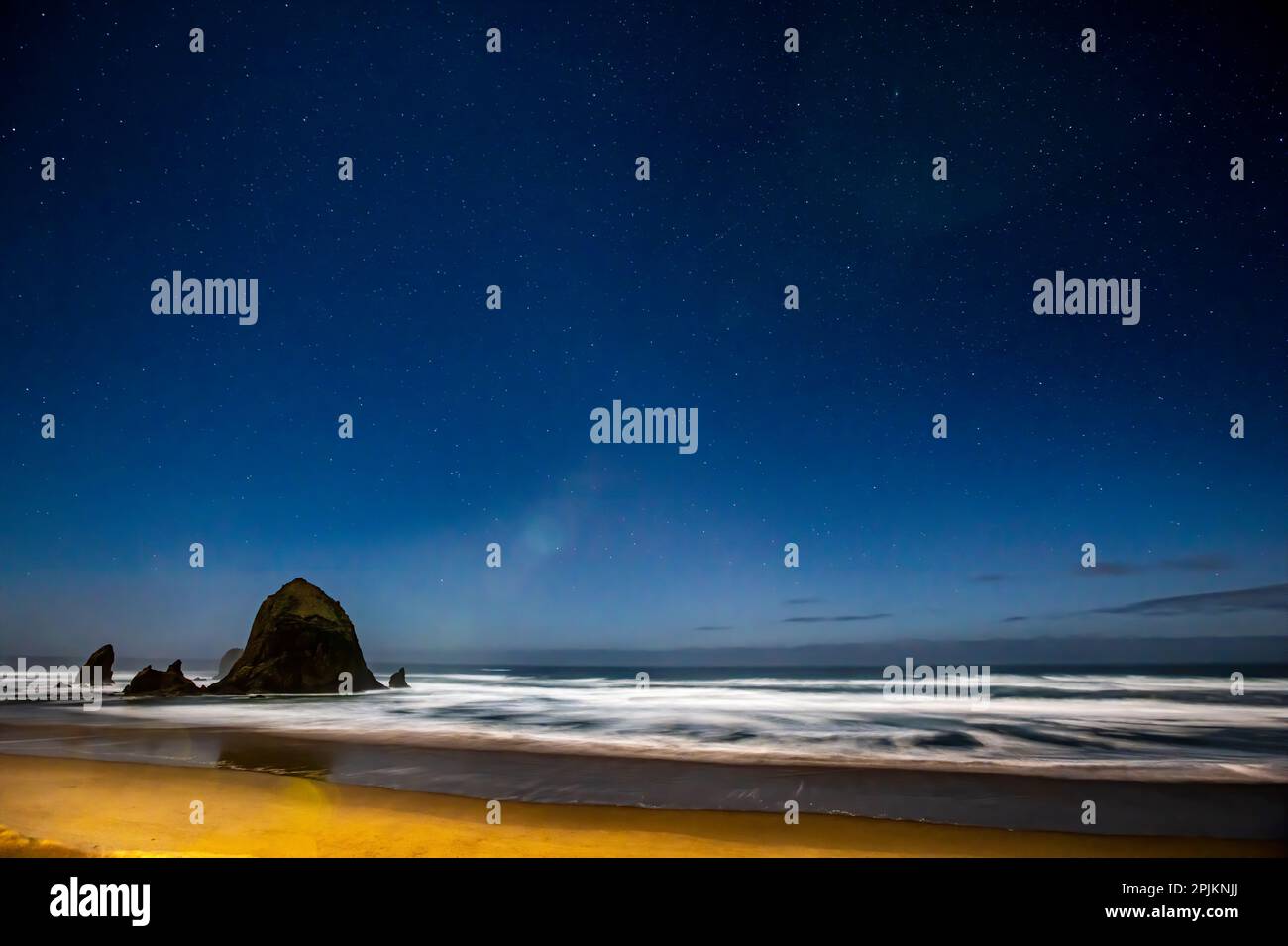 États-Unis, Oregon. Cannon Beach et Haystack Rock sont des stars qui se manifestent sous la lumière bleue. Banque D'Images