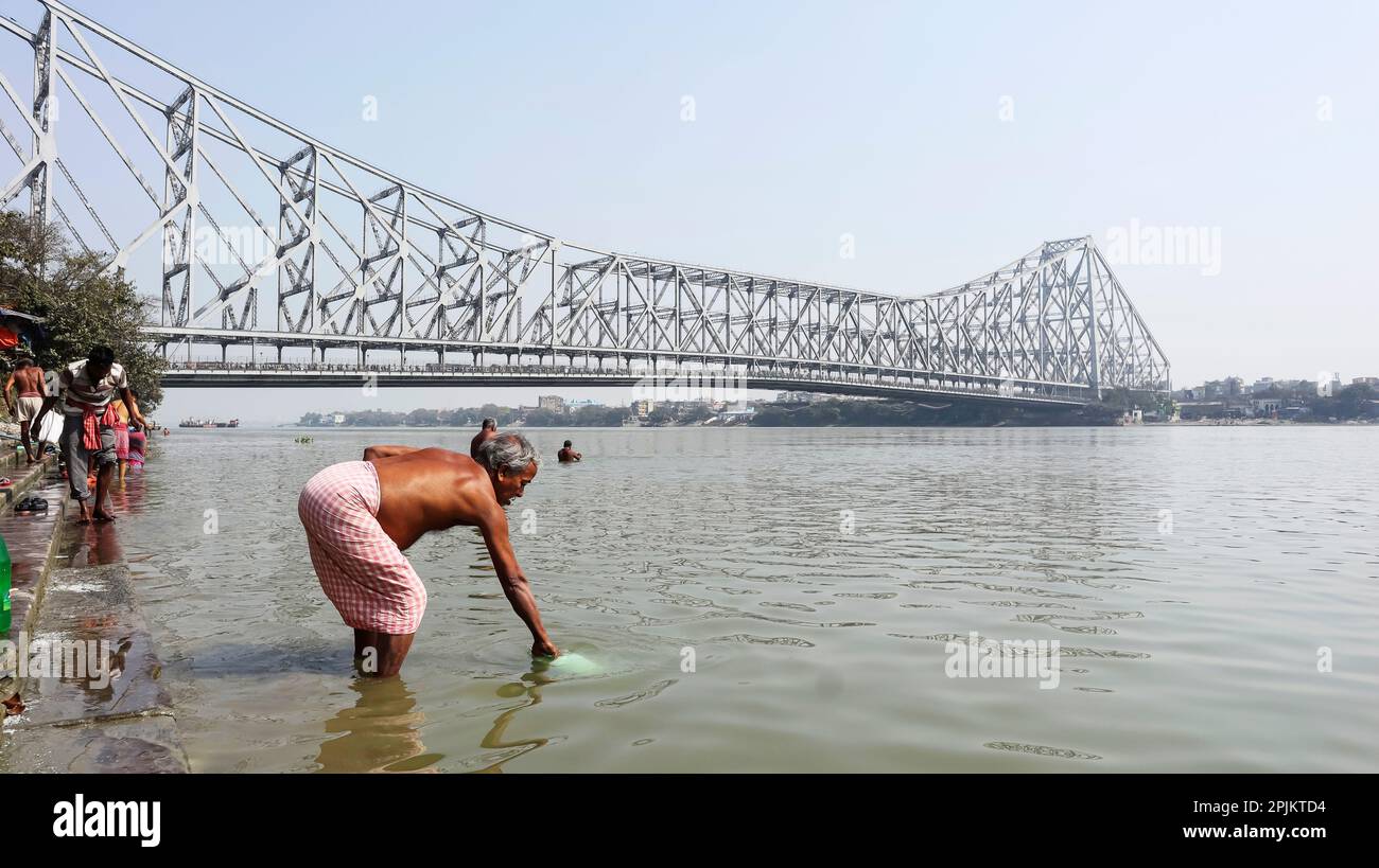 Vue sur le pont Howrah sur la rivière Hooghly, les peuples prenant Bath dans la rivière, Kolkata, Bengale-Occidental, Inde. Banque D'Images