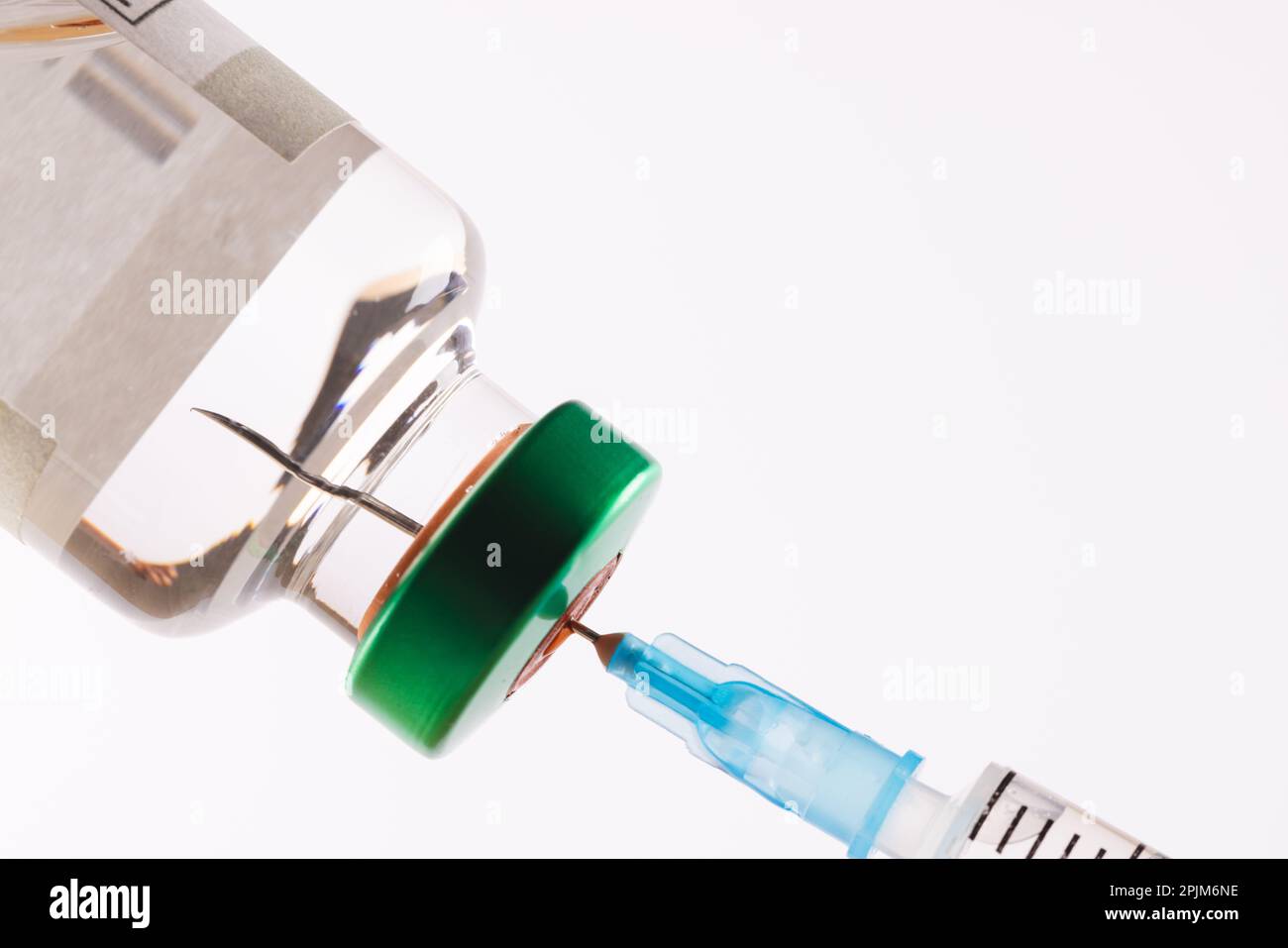 Remplissage de la seringue à partir d'un flacon de liquide clair tel que l'insuline, sur fond blanc avec espace de copie Banque D'Images