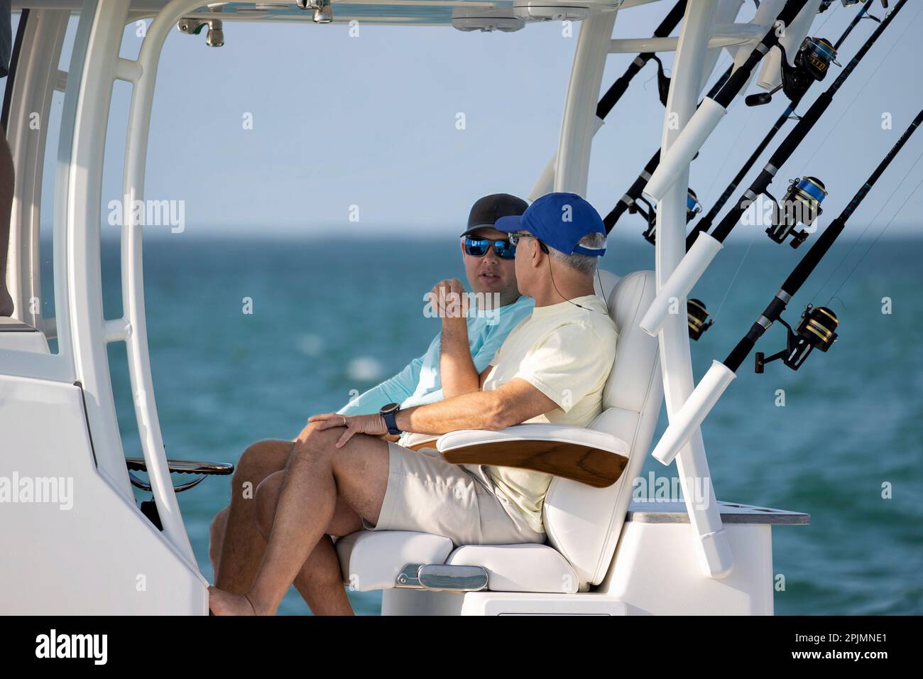 Deux hommes assis sur un bateau de pêche de la console centrale. Banque D'Images