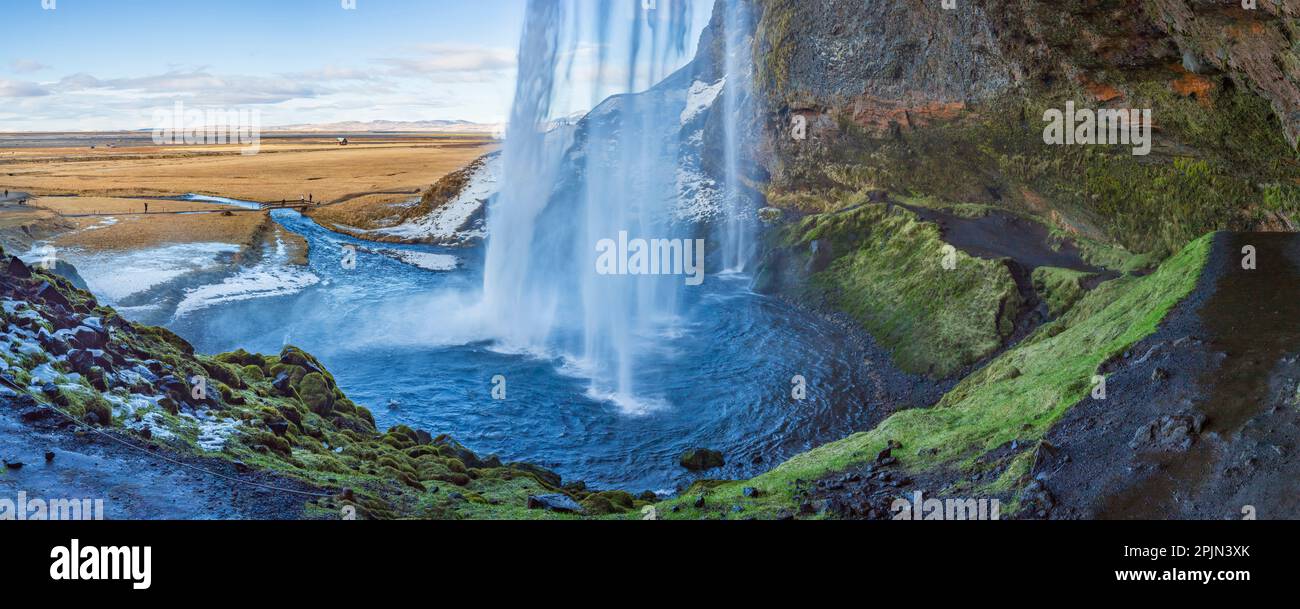 Vue sur Seljalandsfoss depuis l'intérieur de la cascade lors d'une belle journée d'hiver, en Islande. Banque D'Images