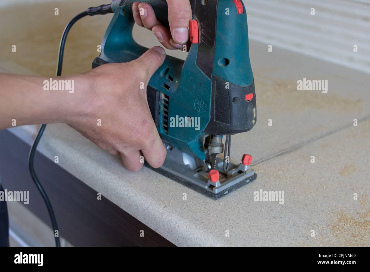 l'homme coupe les meubles de comptoir sur la scie électrique de cuisine  Photo Stock - Alamy