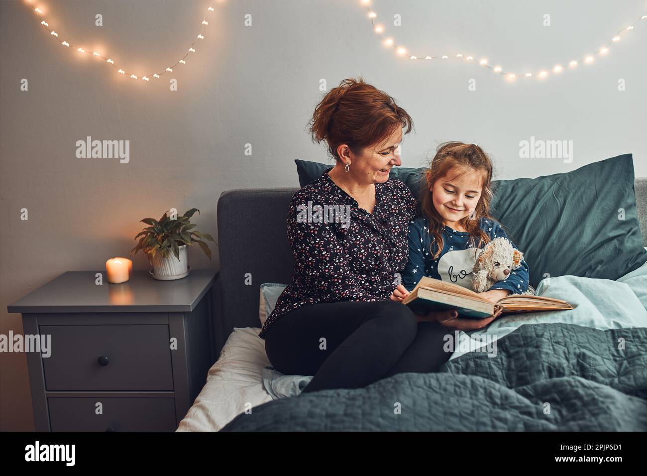 Mère lisant livre sa fille dans le lit avant d'aller dormir. Lire des histoires avant de dormir. Histoires de coucher pour enfant Banque D'Images