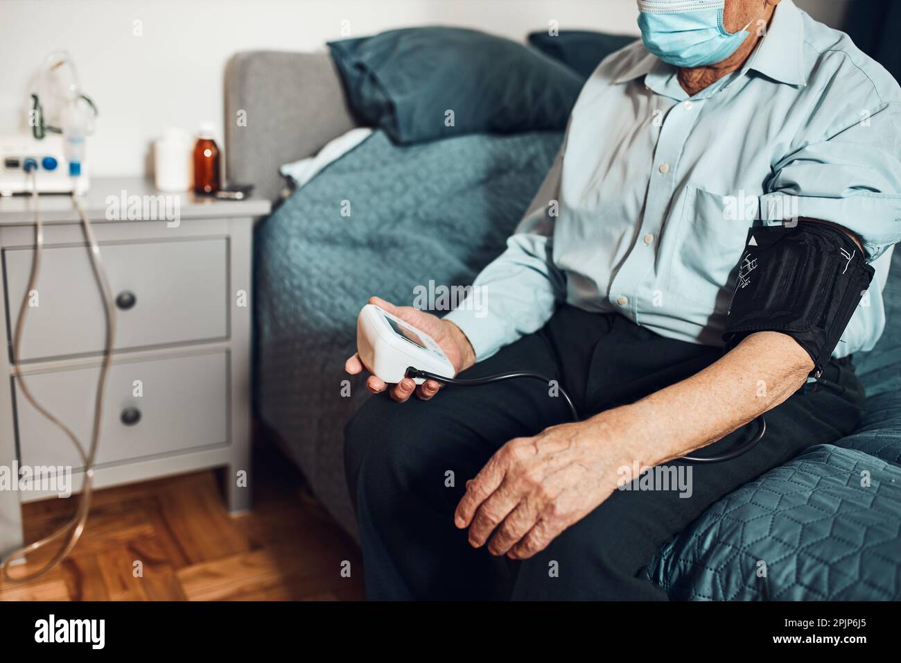 Homme âgé mesurant lui-même la tension artérielle et la fréquence cardiaque. Vérification de l'état de santé du patient aîné souffrant d'hypertension artérielle Banque D'Images